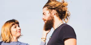young woman touching her husband's beard outdoors