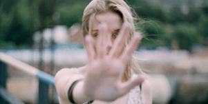 woman holding her hand palm in front of her face